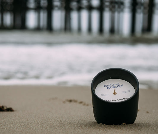 Candle sitting in the sand on Ventura Beach